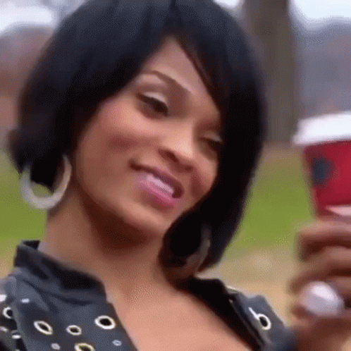 A Close Up Of A Woman Holding A Cup Of Coffee . GIF
