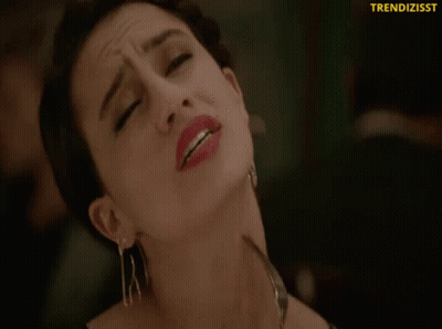 A Close Up Of A Woman Holding A Fork To Her Neck With The Words Trendizisst On The Bottom GIF