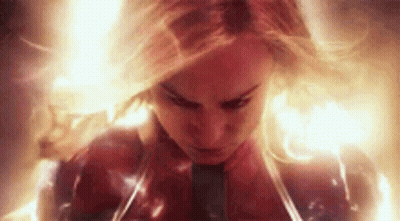 A Close Up Of A Woman In A Superhero Costume Surrounded By Flames . GIF