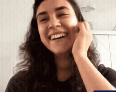 A Close Up Of A Woman Laughing With Her Hand On Her Chin GIF