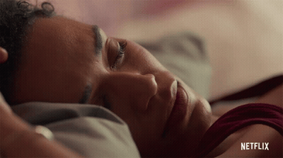 A Close Up Of A Woman Laying In Bed With Netflix Written On The Bottom GIF