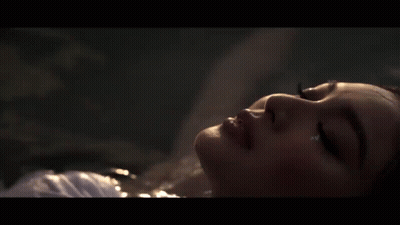 A Close Up Of A Woman Laying In The Water GIF