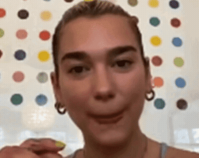 A Close Up Of A Woman Making A Funny Face In Front Of A Wall With Polka Dots . GIF