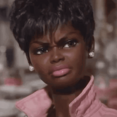 A Close Up Of A Woman Making A Funny Face Wearing A Pink Jacket GIF