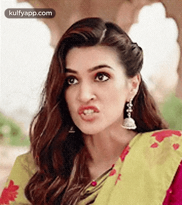 A Close Up Of A Woman Making A Funny Face While Wearing A Saree And Earrings . GIF