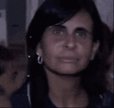 A Close Up Of A Woman Making A Funny Face While Wearing Ear Buds . GIF
