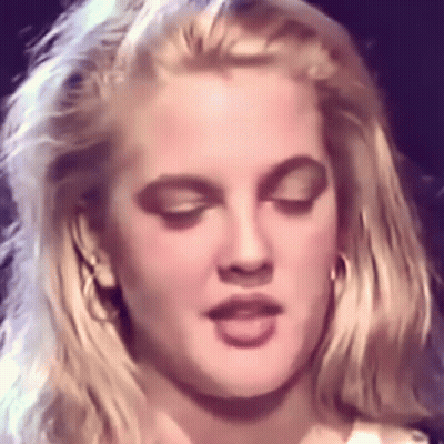 A Close Up Of A Woman Making A Funny Face With Her Eyes Closed . GIF