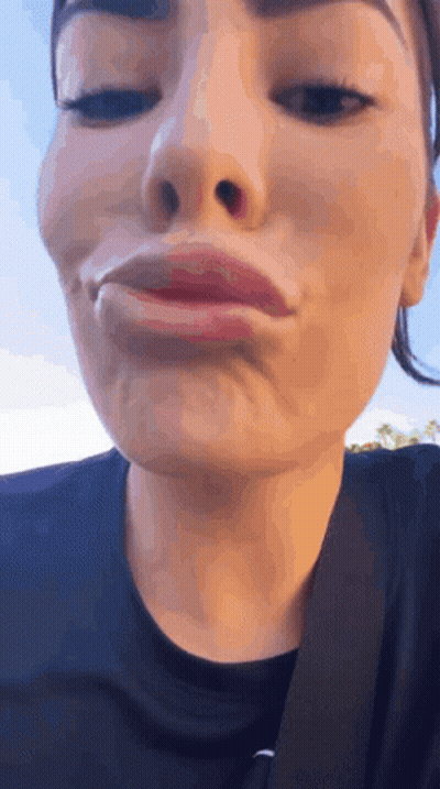 A Close Up Of A Woman Making A Funny Face With Her Eyes Closed . GIF
