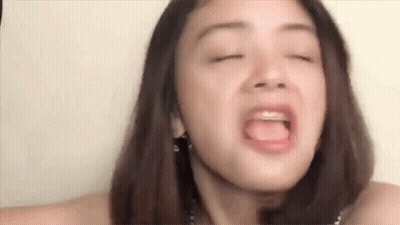 A Close Up Of A Woman Making A Funny Face With Her Eyes Closed And Her Tongue Out . GIF