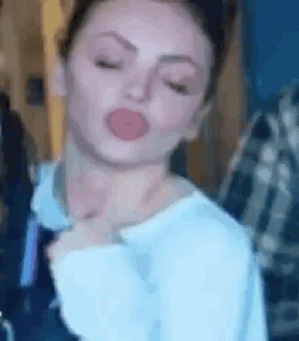 A Close Up Of A Woman Making A Funny Face With Her Eyes Closed And Her Tongue Out . GIF