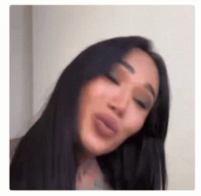 A Close Up Of A Woman Making A Funny Face With Her Eyes Closed . GIF