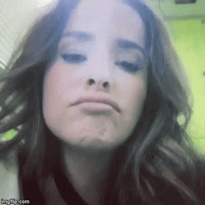 A Close Up Of A Woman Making A Funny Face With Her Eyes Closed . GIF