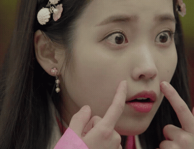 A Close Up Of A Woman Making A Funny Face With Her Fingers GIF