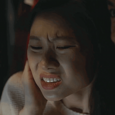A Close Up Of A Woman Making A Funny Face With Her Hand On Her Ear GIF