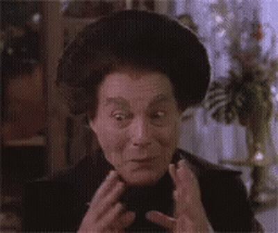 A Close Up Of A Woman Making A Funny Face With Her Hands On Her Face . GIF