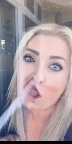 A Close Up Of A Woman Making A Funny Face With Her Tongue Out GIF