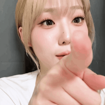 A Close Up Of A Woman Making A Heart With Her Finger GIF