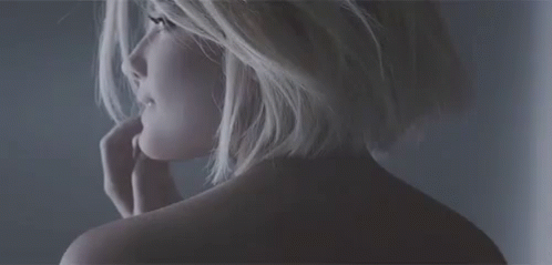 A Close Up Of A Woman 'S Back With A Hand On Her Face . GIF
