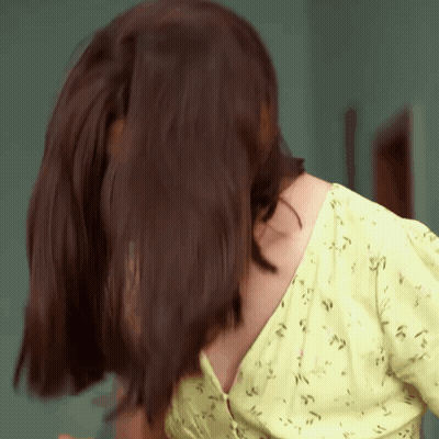 A Close Up Of A Woman 'S Back With Her Hair Blowing In The Wind GIF