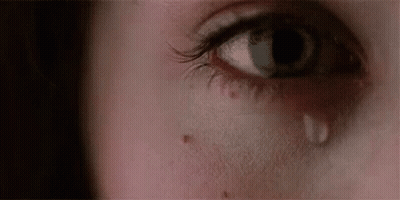 A Close Up Of A Woman 'S Eye With A Tear On It . GIF