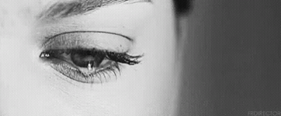 A Close Up Of A Woman 'S Eye With A Tear Running Down It . GIF