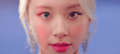 A Close Up Of A Woman 'S Eye With Glitter On It And A Red Background . GIF