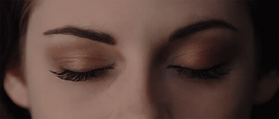 A Close Up Of A Woman 'S Eyes With A Dark Background GIF