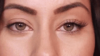 A Close Up Of A Woman 'S Eyes With False Eyelashes And Makeup . GIF