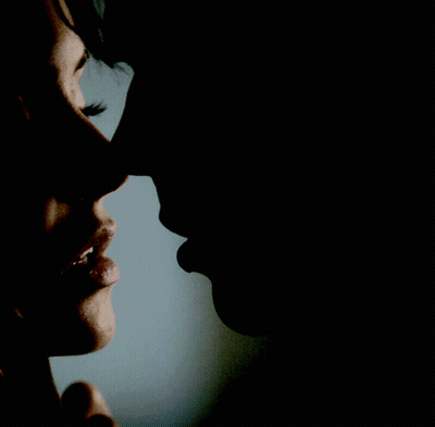 A Close Up Of A Woman 'S Face And A Man 'S Face In The Dark GIF