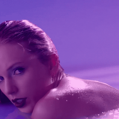 A Close Up Of A Woman 'S Face And Shoulder With Purple Background GIF