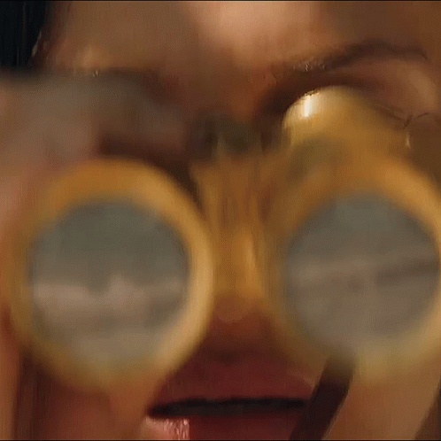 A Close Up Of A Woman 'S Face Behind A Glass GIF