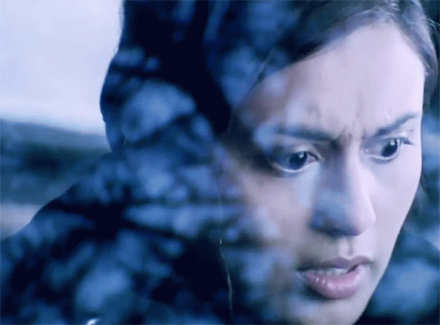 A Close Up Of A Woman 'S Face Behind A Glass GIF