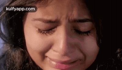 A Close Up Of A Woman 'S Face Crying With Her Eyes Closed . GIF