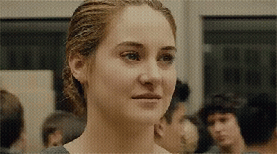 A Close Up Of A Woman 'S Face In A Crowded Room . GIF