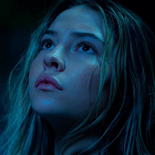 A Close Up Of A Woman 'S Face In A Dark Room GIF