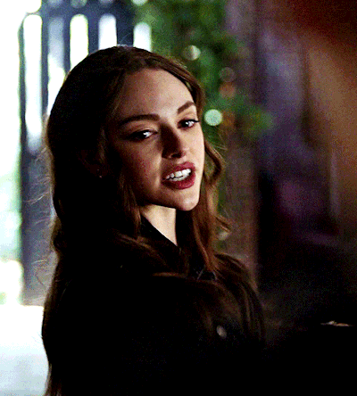 A Close Up Of A Woman 'S Face In A Dark Room GIF