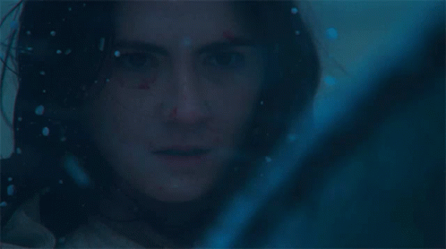 A Close Up Of A Woman 'S Face In A Dark Room GIF