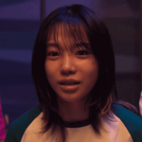 A Close Up Of A Woman 'S Face In A Dark Room . GIF