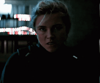 A Close Up Of A Woman 'S Face In A Dark Room With A Blurry Background . GIF