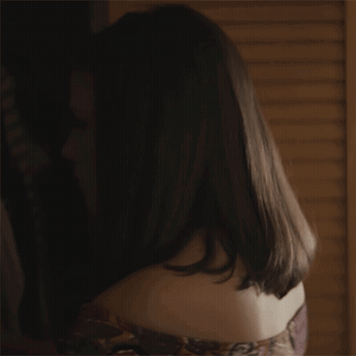 A Close Up Of A Woman 'S Face In A Dark Room With A Lamp In The Background . GIF