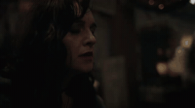 A Close Up Of A Woman 'S Face In A Dark Room With Her Eyes Closed . GIF