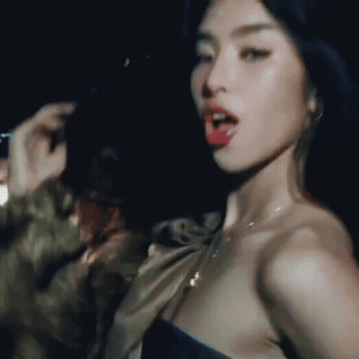 A Close Up Of A Woman 'S Face In A Dark Room With Her Mouth Open GIF