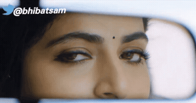 A Close Up Of A Woman 'S Face In A Rear View Mirror With A Twitter Logo In The Background GIF