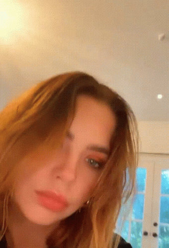 A Close Up Of A Woman 'S Face In A Room GIF