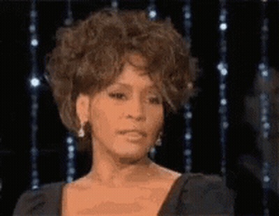 A Close Up Of A Woman 'S Face In Front Of A Black Background . GIF