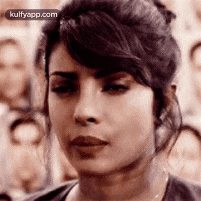 A Close Up Of A Woman 'S Face In Front Of A Crowd . GIF