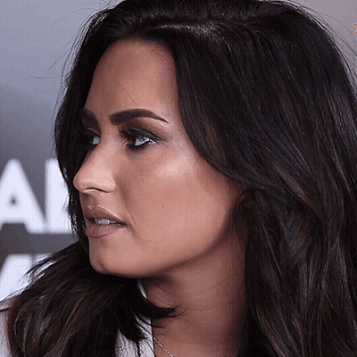 A Close Up Of A Woman 'S Face In Front Of A Sign That Says All GIF