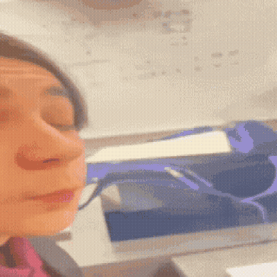 A Close Up Of A Woman 'S Face In Front Of A White Board With Numbers On It GIF