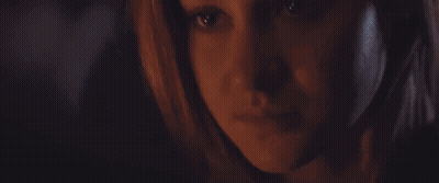 A Close Up Of A Woman 'S Face In The Dark GIF