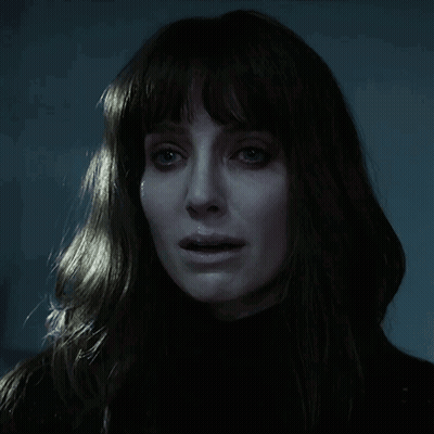 A Close Up Of A Woman 'S Face In The Dark GIF